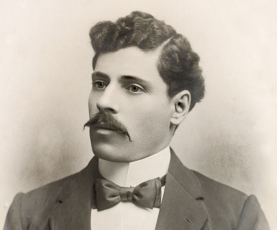 A formal portrait of Betro Abicare wearing a dark suit and bowtie taken around 1902 
